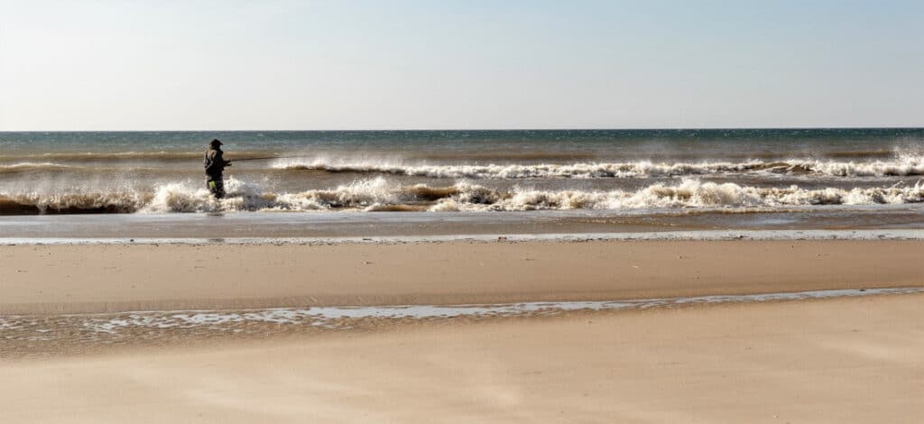 Mann angelt mit neuem Angelschein im Meer